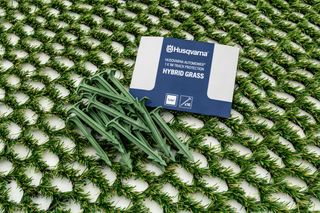 Husqvarna Automower® Hybrid-Grasmatte mit Pfählen und Verpackung.