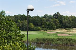 Un terrain de golf avec une station de référence Husqvarna au premier plan.
