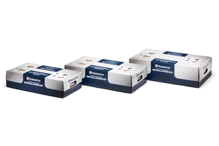 Three Husqvarna installation kit boxes displayed in a studio setting.