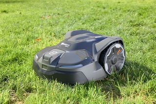 Robotic lawn mower operating on a grassy lawn.