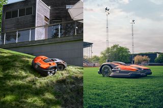 Two robotic lawn mowers operating on grassy slopes in a park setting.