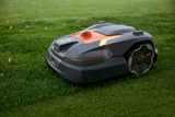 Robotic lawn mower operating on a grassy lawn.