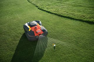 Robotic lawn mower operating in a garden with a satellite signal icon overlay.