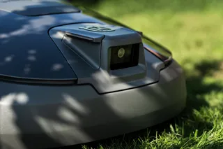 Close-up of a robotic lawn mower on grass.