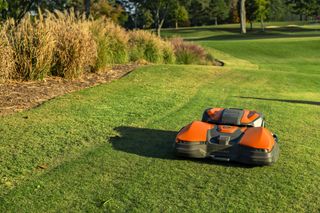 Robotic lawn mower operating on a well-maintained golf course.