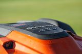 Zbliżenie na kosiarkę Husqvarna Automower z widocznym brandingiem.