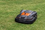 Robotic lawn mower operating on a grassy lawn.