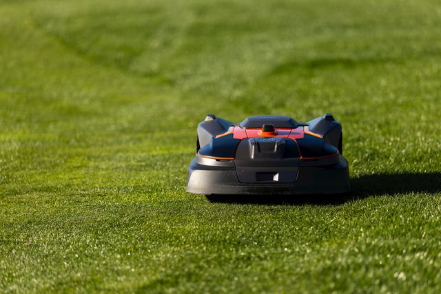 Robotic lawn mower operating on a well-maintained grassy lawn.
