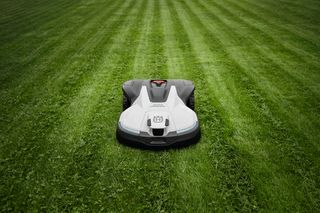 Robotic lawn mower operating on a well-maintained lawn.