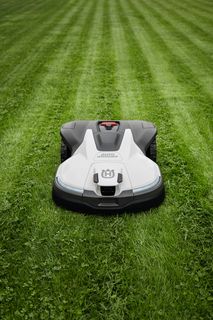 Robotic lawn mower operating on a well-maintained lawn.