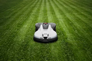 Robotic lawn mower operating on a well-maintained lawn.