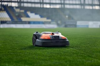 Robotic lawn mower operating on a sports field.