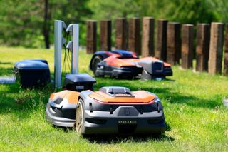 庭のチャージステーションの近くにあるロボット芝刈機ハスクバーナロゴが表示されます。