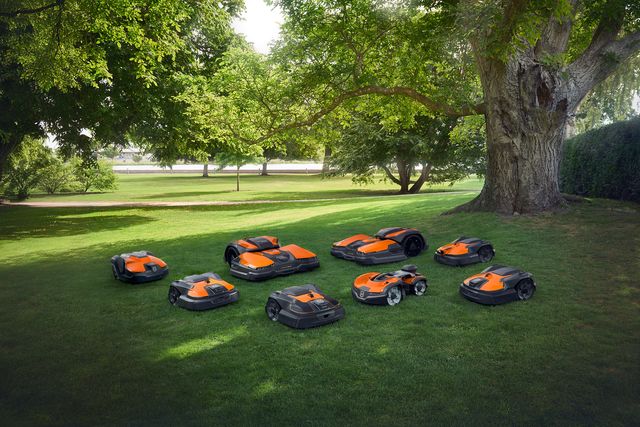 Several robotic lawn mowers in a park setting