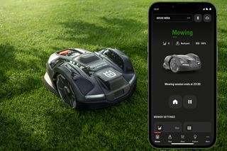 Robotic lawn mower operating in a garden with a smartphone app displaying mowing settings.