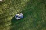 Robotic lawn mower operating on a well-maintained grassy lawn.