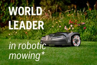 A robotic lawn mower on a grassy lawn with flowers in the background, featuring text 'World Leader in robotic mowing'.