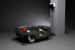 Mähroboter wird an einer Ladestation im Haus geparkt.