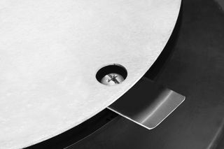 Nahaufnahme eines Metallbauteils mit kreisförmiger Bauform und vorstehender Lasche.