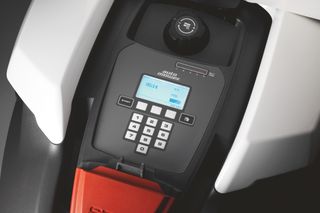 Gros plan sur un panneau de commande d’un robot tondeuse, doté d’un clavier et d’un écran d’affichage.