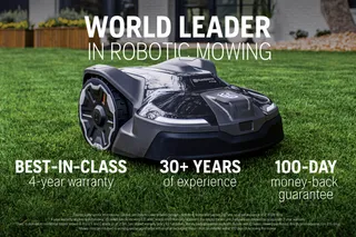 Robotic lawn mower on grass with text highlighting warranty and experience.