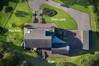Aerial view of a house with labeled areas: front lawn, play area, and slope.