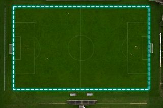 Top view of a football field with a glowing blue border outlining the pitch.