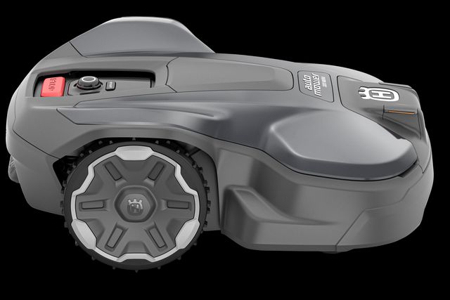 Zijaanzicht van een Husqvarna robotmaaier met zichtbaar bedieningspaneel en wielen.