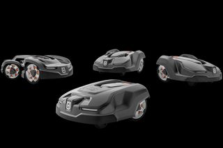 Four Husqvarna robotic lawn mowers displayed in a studio setting.