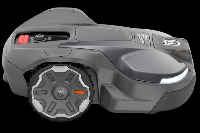 Zijaanzicht van een Husqvarna robotmaaier met zichtbaar bedieningspaneel en wielen.