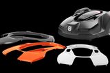 Husqvarna robotic lawn mower with three interchangeable covers in different colors.