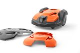 Husqvarna robotic lawn mower with two interchangeable covers displayed in a studio setting.