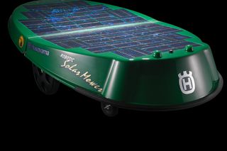 Vista lateral de un robot cortacésped Husqvarna con paneles solares visibles.