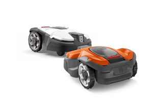 Two Husqvarna robotic lawn mowers, one orange and one white, shown from a side angle.