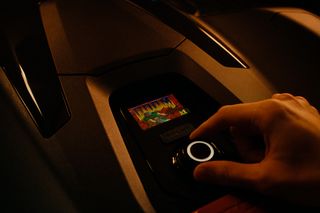 En hand som justerar inställningarna på en robotgräsklippares kontrollpanel.