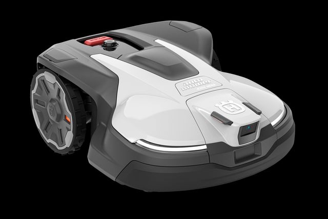 Robotic lawn mower with a visible control panel and large wheel, shown in a studio setting.