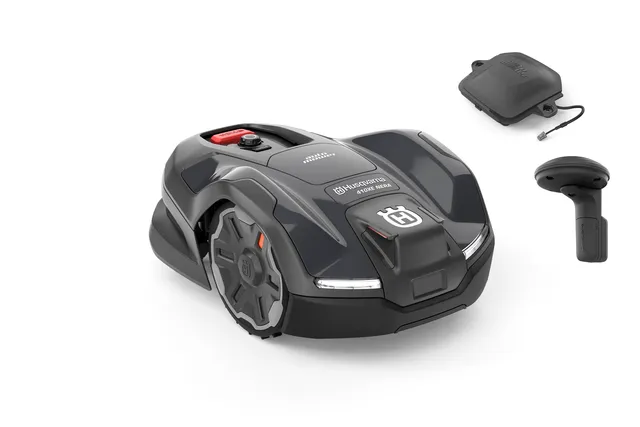 Side view of a Husqvarna robotic lawn mower with accessories.