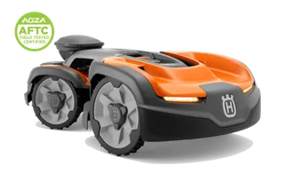 Studio front-side view of a Husqvarna robotic lawn mower with LED lights and AGZA AFTC badge.