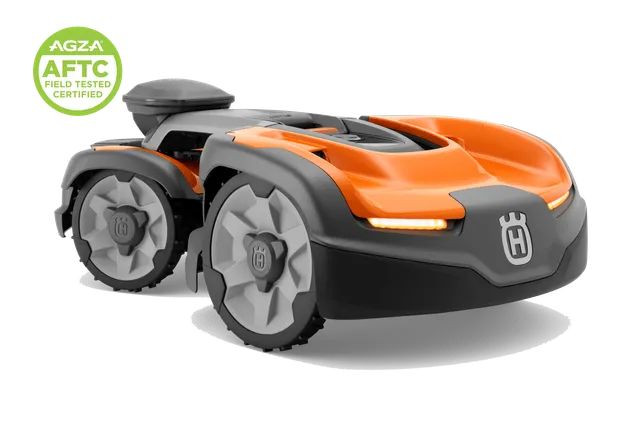 Studio front-side view of a Husqvarna robotic lawn mower with LED lights and AGZA AFTC badge.