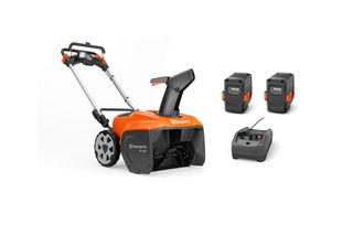 Side view of a Husqvarna snow blower with discharge chute, plus two batteries and a charger.