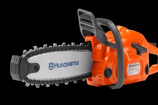 Seitenansicht einer Husqvarna Motorsäge mit sichtbarem Branding und Kettendetails.