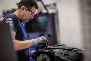 A person working on a product in a workshop setting, with focus on the product.