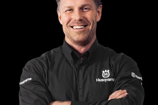 Person wearing a Husqvarna branded shirt with arms crossed.