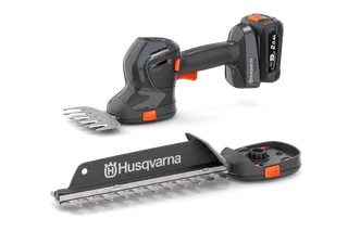 Вигляд спереду акумуляторних газонних ножиць і кущоріза Husqvarna зі змінними лезами.
