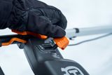 Людина в рукавичках регулює рукоятку снігоочисника Husqvarna.
