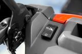 Close-up de um painel de controlo numa ferramenta de jardim, com um interruptor com um ícone de avião.