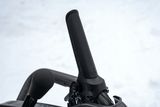 Close-up of a handlebar grip on a snow-covered surface.