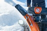 Une personne qui utilise une souffleuse à neige dans un environnement enneigé.