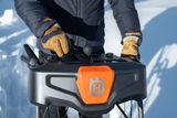 Une personne qui utilise une souffleuse à neige Husqvarna dans un environnement enneigé.