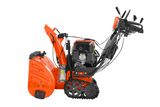 Side view of a snow blower with visible engine and control handles.